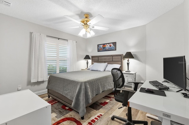 2120 Callaway Dr, The Villages, FL 32162 - bedroom featuring a textured ceiling, ceiling fan, light wood-type flooring, and baseboards