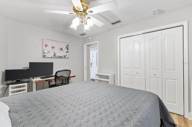 2120 Callaway Dr, The Villages, FL 32162 - bedroom featuring a textured ceiling, visible vents, a closet, and wood finished floors