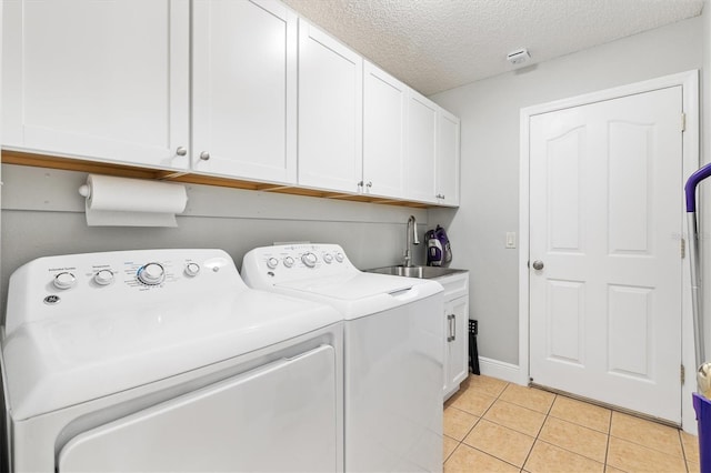 2120 Callaway Dr, The Villages, FL 32162 - laundry room with a sink, washing machine and clothes dryer, cabinet space, light tile patterned flooring, and a textured ceiling