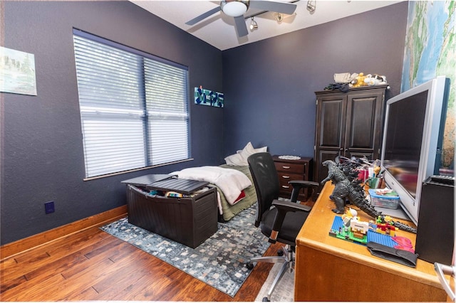 bedroom featuring baseboards, wood finished floors, and ceiling fan