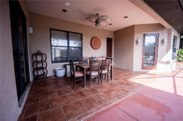 interior space with a ceiling fan, tile patterned flooring, and a textured wall