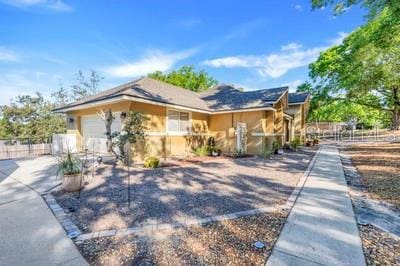 view of front of property featuring fence, concrete driveway, and a garage