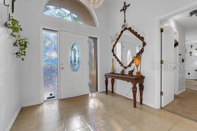 foyer entrance with baseboards and light tile patterned floors