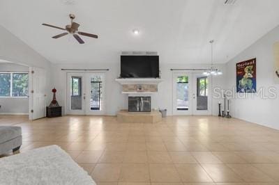unfurnished living room with a glass covered fireplace, ceiling fan, vaulted ceiling, and french doors