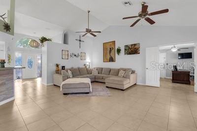 living room with a ceiling fan, high vaulted ceiling, and light tile patterned floors