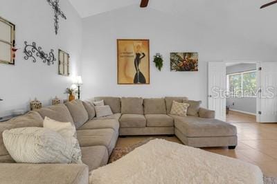 living area featuring ceiling fan, baseboards, and vaulted ceiling with beams