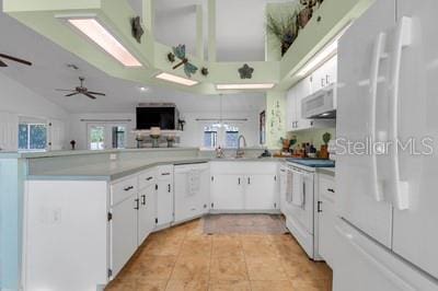 kitchen with plenty of natural light, light tile patterned floors, white cabinetry, and white appliances