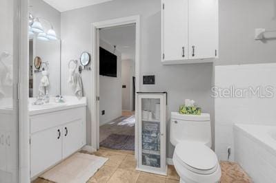 full bath featuring a bath, toilet, vanity, and tile patterned floors