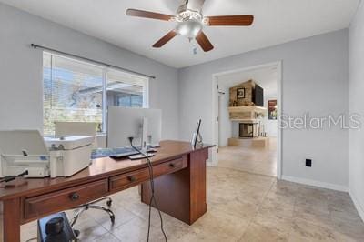 home office featuring baseboards, a fireplace, and ceiling fan