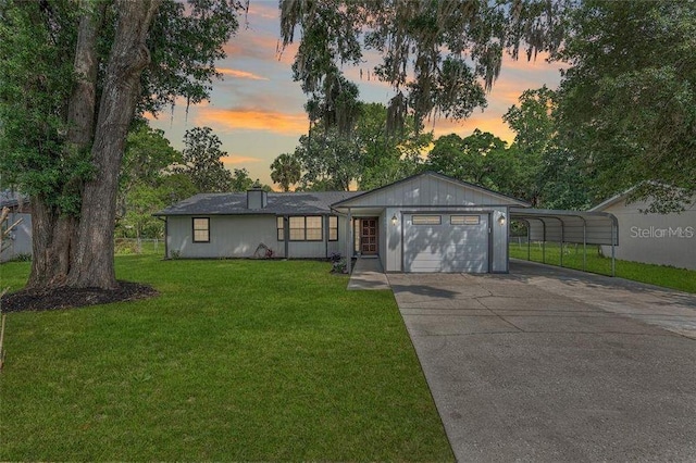 single story home featuring an attached garage, a front lawn, a carport, and concrete driveway