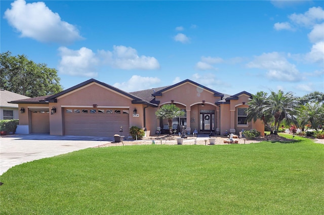 view of front facade with a garage, driveway, a front yard, and stucco siding
