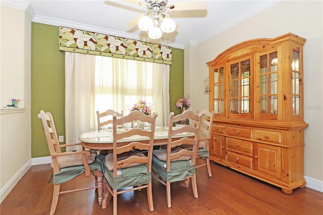dining space with wood finished floors, a ceiling fan, baseboards, and ornamental molding