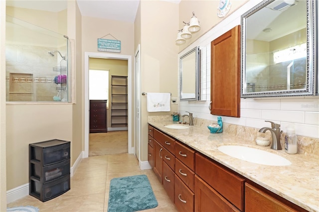 full bathroom with a spacious closet, double vanity, a sink, and a walk in shower