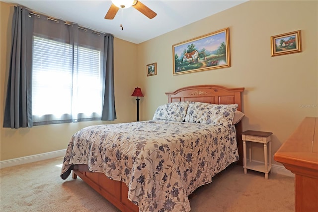 carpeted bedroom with ceiling fan and baseboards