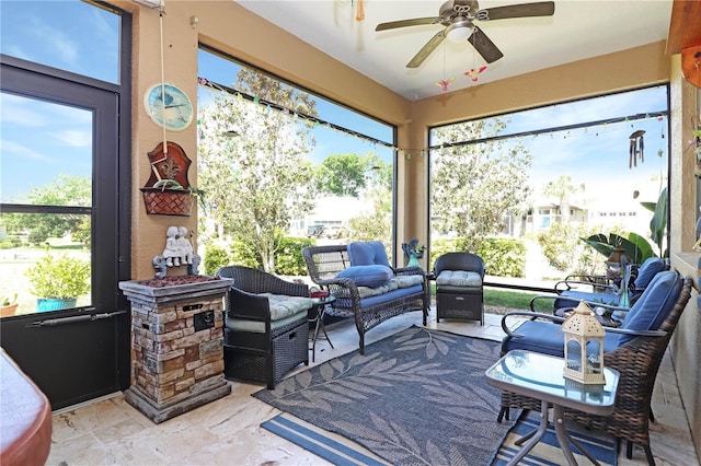 sunroom / solarium featuring ceiling fan and an outdoor living space
