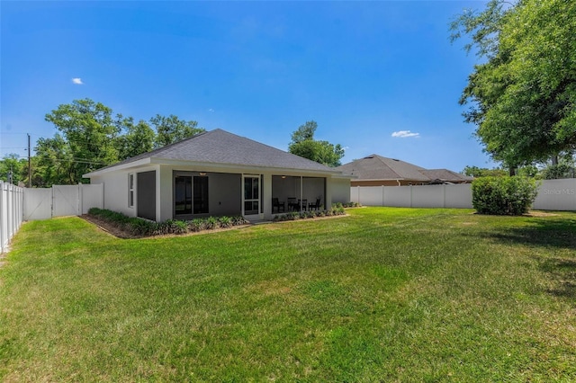 16380 SE 84th Ct, Summerfield, FL 34491 - rear view of house with a lawn, stucco siding, a sunroom, and a fenced backyard