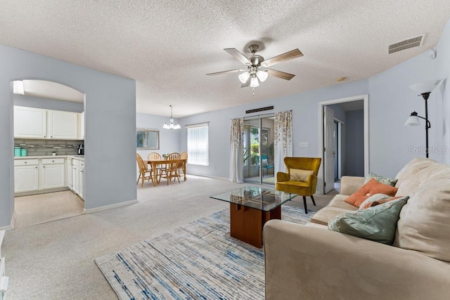 4386 Sambourne St, Clermont, FL 34711 - living room with visible vents, arched walkways, baseboards, light colored carpet, and ceiling fan with notable chandelier