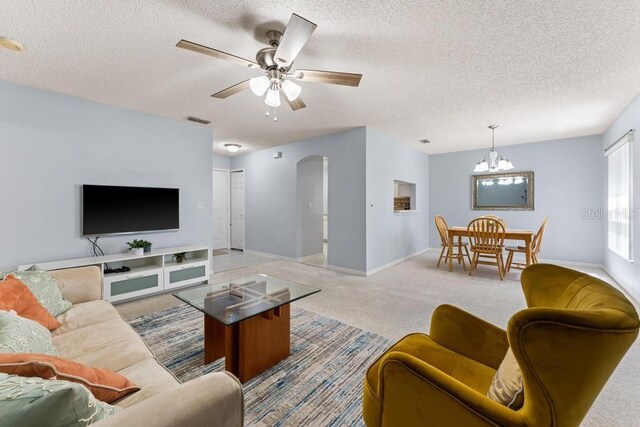 4386 Sambourne St, Clermont, FL 34711 - living area with arched walkways, a textured ceiling, baseboards, visible vents, and light colored carpet