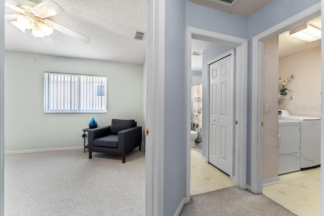 4386 Sambourne St, Clermont, FL 34711 - corridor featuring a textured ceiling, separate washer and dryer, light colored carpet, baseboards, and visible vents