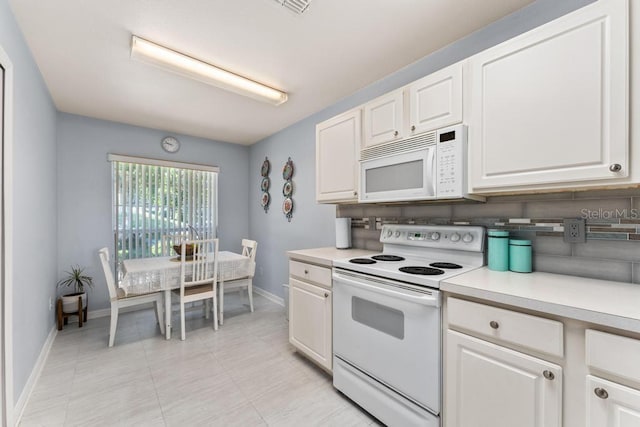4386 Sambourne St, Clermont, FL 34711 - kitchen with light countertops, white cabinets, baseboards, and white appliances