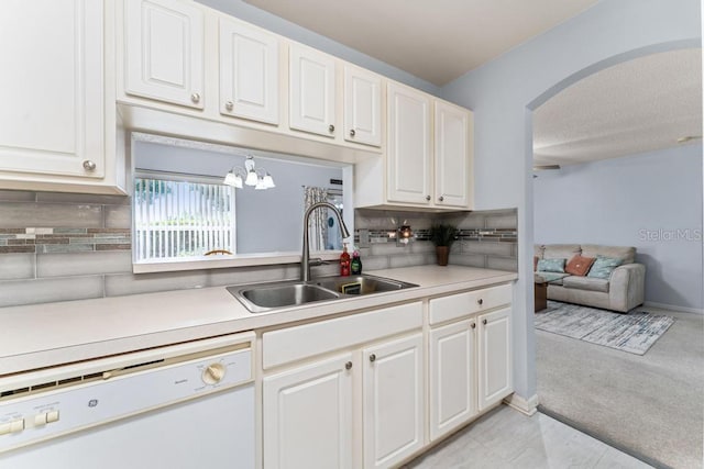 4386 Sambourne St, Clermont, FL 34711 - kitchen featuring light countertops, a sink, white dishwasher, arched walkways, and decorative backsplash