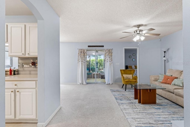 4386 Sambourne St, Clermont, FL 34711 - living area featuring light carpet, a ceiling fan, baseboards, and arched walkways
