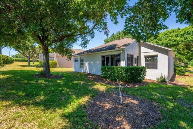 4386 Sambourne St, Clermont, FL 34711 - back of house featuring a lawn and stucco siding