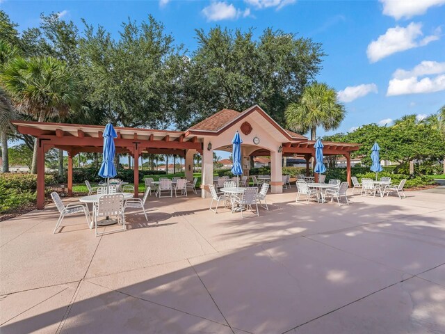view of home's community with a pergola, outdoor dining space, and a patio area