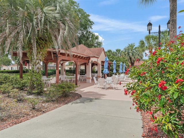 view of home's community featuring outdoor dining area and a patio area