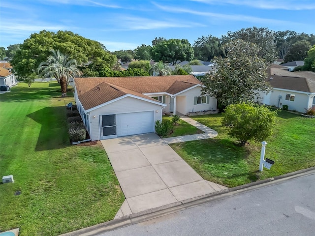 view of front of home with a front yard, an attached garage, concrete driveway, and a residential view