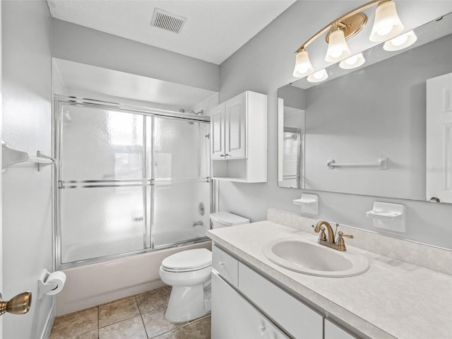 bathroom featuring toilet, vanity, and enclosed tub / shower combo