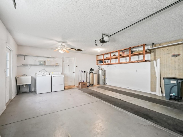garage with washing machine and clothes dryer, electric water heater, a sink, a garage door opener, and ceiling fan