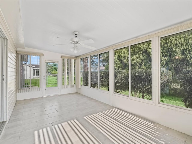 unfurnished sunroom featuring a ceiling fan