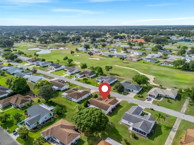 aerial view of residential area featuring a nearby body of water and a local golf course