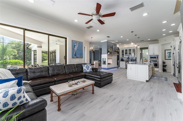 1111 Myrtle Breezes Ct, Fruitland Park, FL 34731 - living area featuring ornamental molding, a ceiling fan, recessed lighting, light wood-type flooring, and baseboards