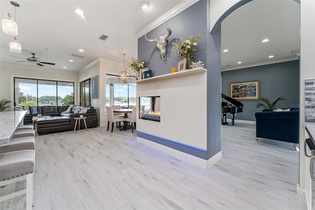 1111 Myrtle Breezes Ct, Fruitland Park, FL 34731 - living room featuring crown molding, ceiling fan, baseboards, recessed lighting, and light wood-style flooring