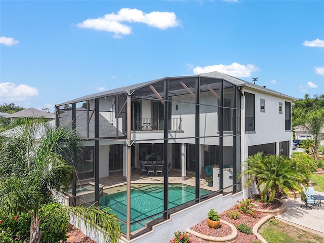 1111 Myrtle Breezes Ct, Fruitland Park, FL 34731 - back of property with a patio area, a balcony, stucco siding, an outdoor pool, and glass enclosure