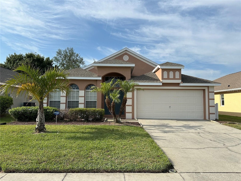 15439 Markham Dr, Clermont, FL 34714 - view of front facade featuring concrete driveway, an attached garage, stucco siding, roof with shingles, and a front yard