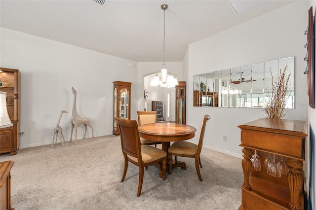 dining space featuring carpet floors, arched walkways, baseboards, and a chandelier