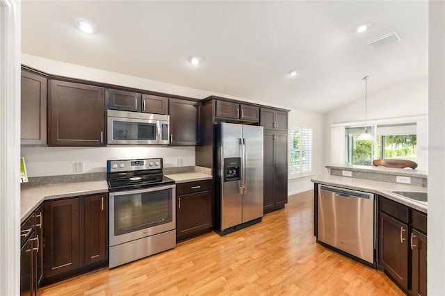 kitchen with visible vents, dark brown cabinets, light countertops, vaulted ceiling, and stainless steel appliances