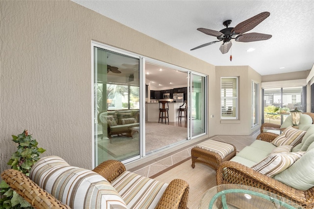 sunroom featuring a ceiling fan and outdoor lounge area