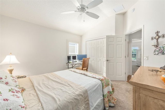 bedroom with light colored carpet, a closet, vaulted ceiling, and multiple windows