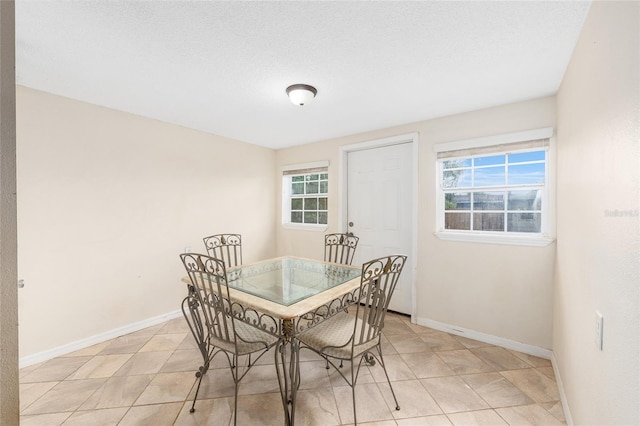 dining room with baseboards and light tile patterned floors
