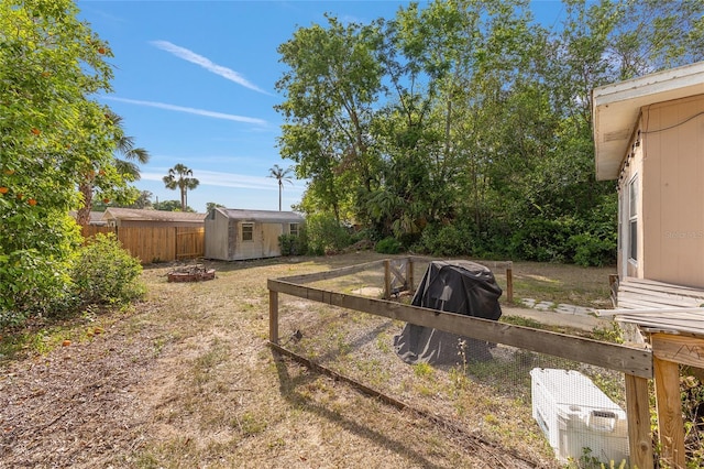 view of yard featuring an outbuilding, a shed, and fence