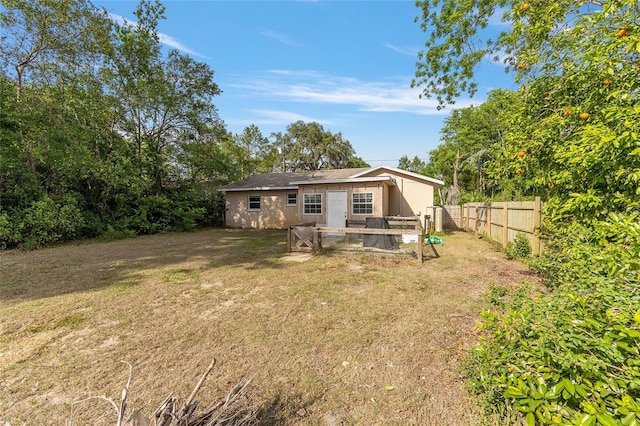 back of house with a yard and a fenced backyard