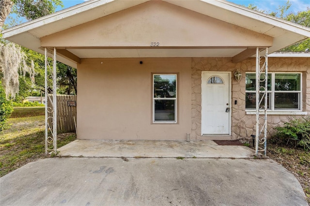 view of front of house with stucco siding, fence, and a patio area