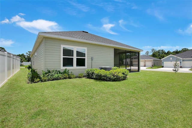 7796 SW 74th Loop, Ocala, FL 34481 - rear view of house with central AC unit, a detached garage, fence, a yard, and a sunroom
