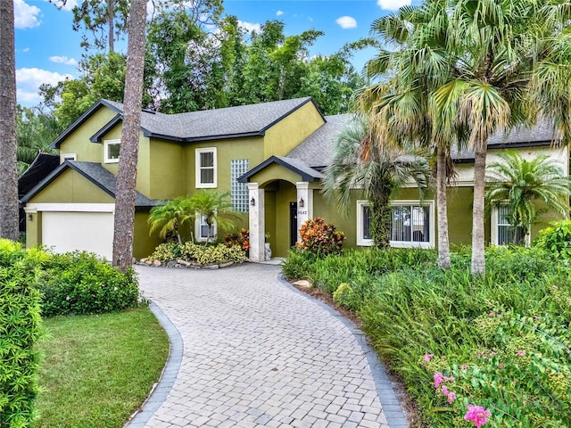 9642 Bear Lake Rd, Apopka, FL 32703 - view of front facade featuring roof with shingles, stucco siding, and decorative driveway