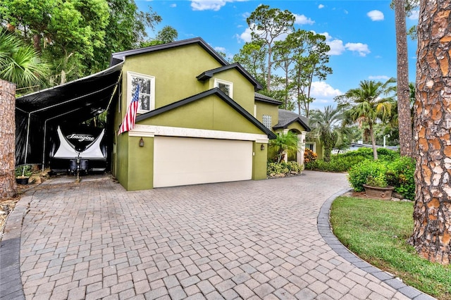 9642 Bear Lake Rd, Apopka, FL 32703 - view of property exterior featuring a garage, decorative driveway, and stucco siding