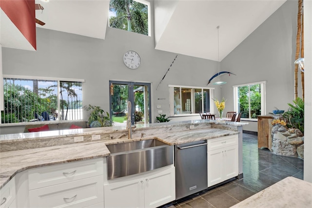 9642 Bear Lake Rd, Apopka, FL 32703 - kitchen with light stone countertops, a sink, high vaulted ceiling, white cabinetry, and stainless steel dishwasher